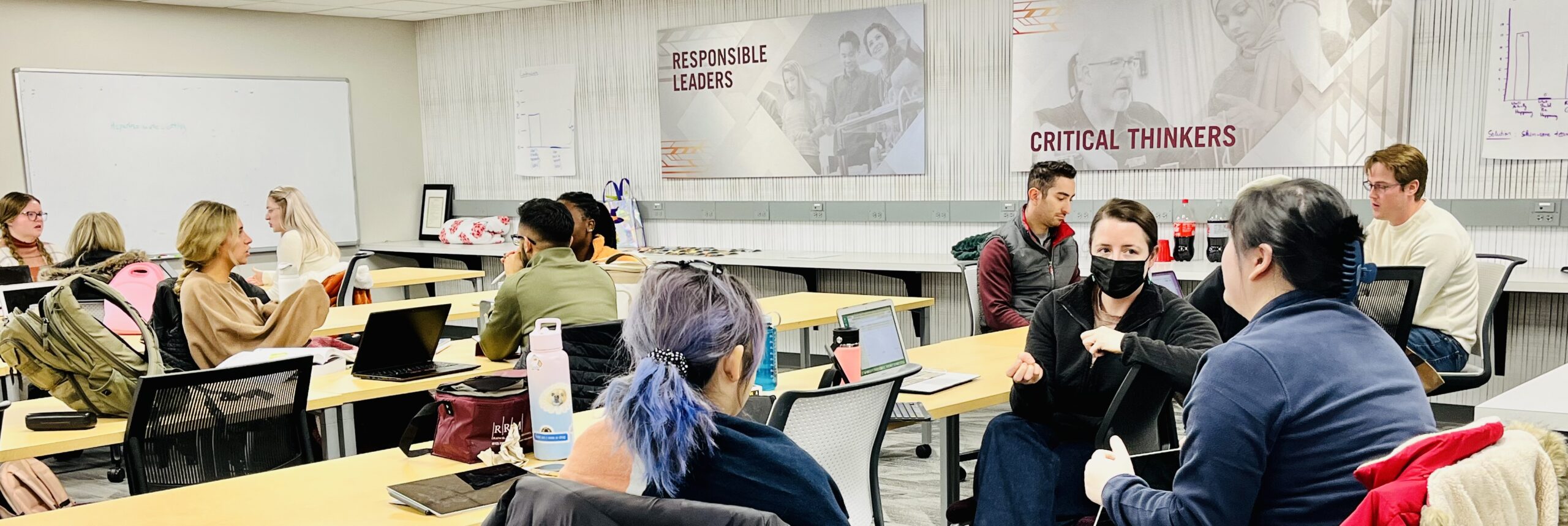 students sitting in a classroom wit posters that read "responsible leaders" and "critical thinkers"